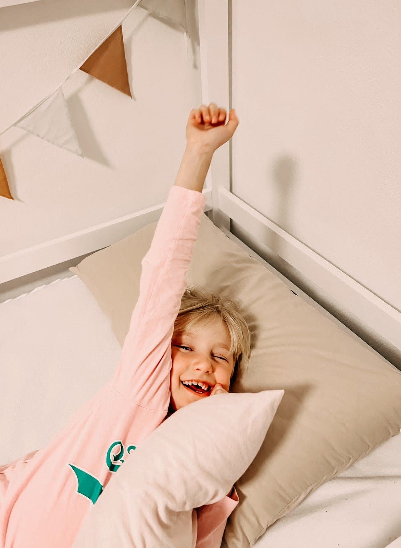 Kind kuschelt sich genüsslich in Annabelle’s ergonomisches Kinderkopfkissen im Bett – mit VitaGlow-Bezug, stützend & atmungsaktiv, handgefertigt in Bayern