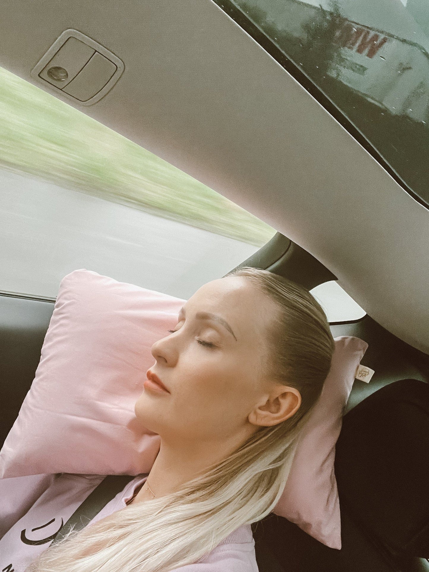 Frau schläft entspannt im Auto auf Annabelle’s Reisekissen mit ergonomischem Memory Foam und VitaGlow-Bezug, handgefertigt in Bayern