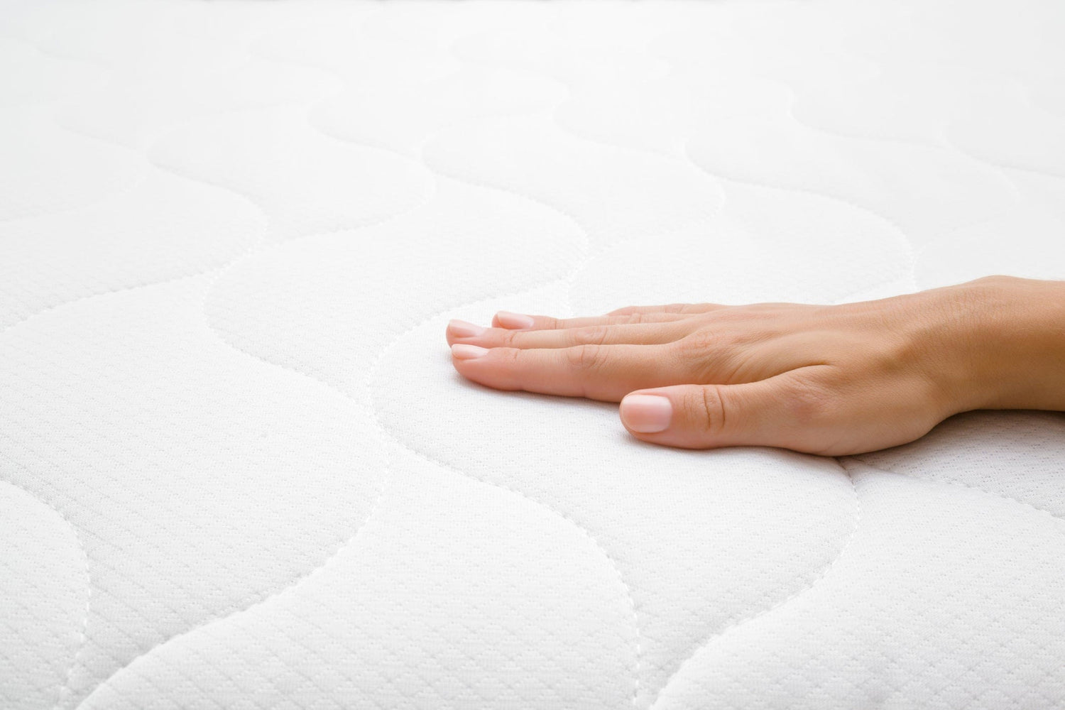 Detailansicht des VitaGlow-Bezugs der BellaSleep Matratze – weibliche Hand fühlt die weiche, strukturierte Oberfläche