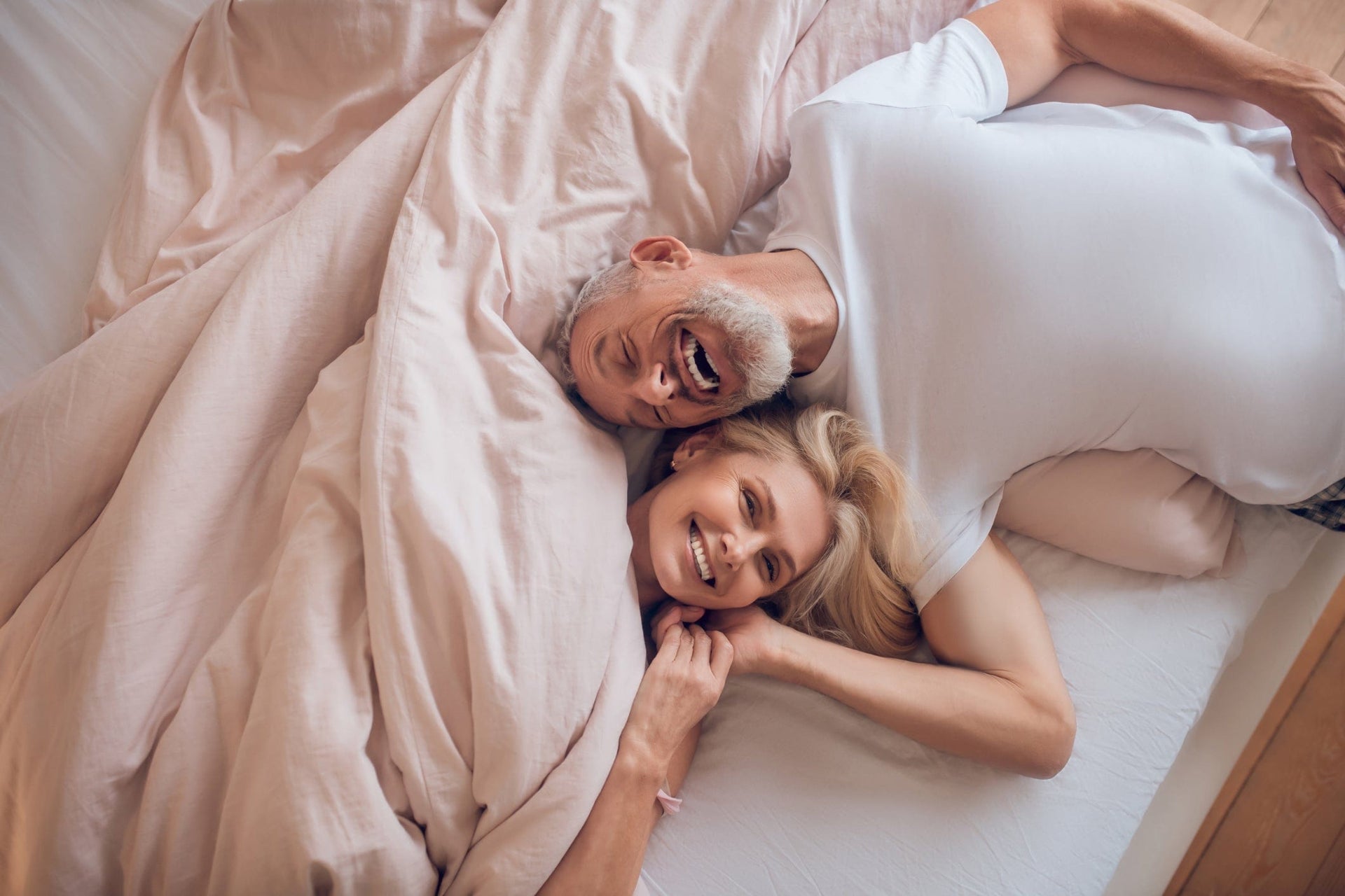 Älteres Paar liegt entspannt im Bett auf der BellaSleep Comfort Matratze 25 cm – mit integriertem Topper für höchsten Komfort