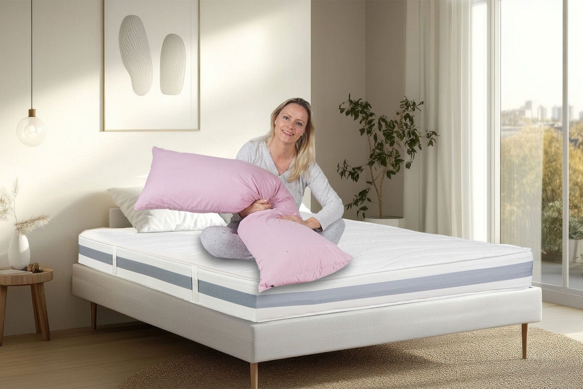 Laura sitzt auf dem Bett mit der BellaSleep Basic Matratze 20 cm – ergonomischer Komfort mit VitaGlow-Bezug