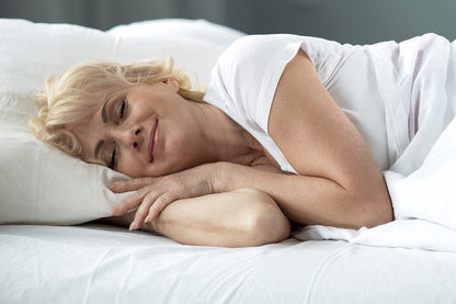 Frau liegt entspannt im Bett und genießt den hohen Annabelle’s Deluxe Topper 12 cm – spürbarer Komfort für erholsamen Schlaf